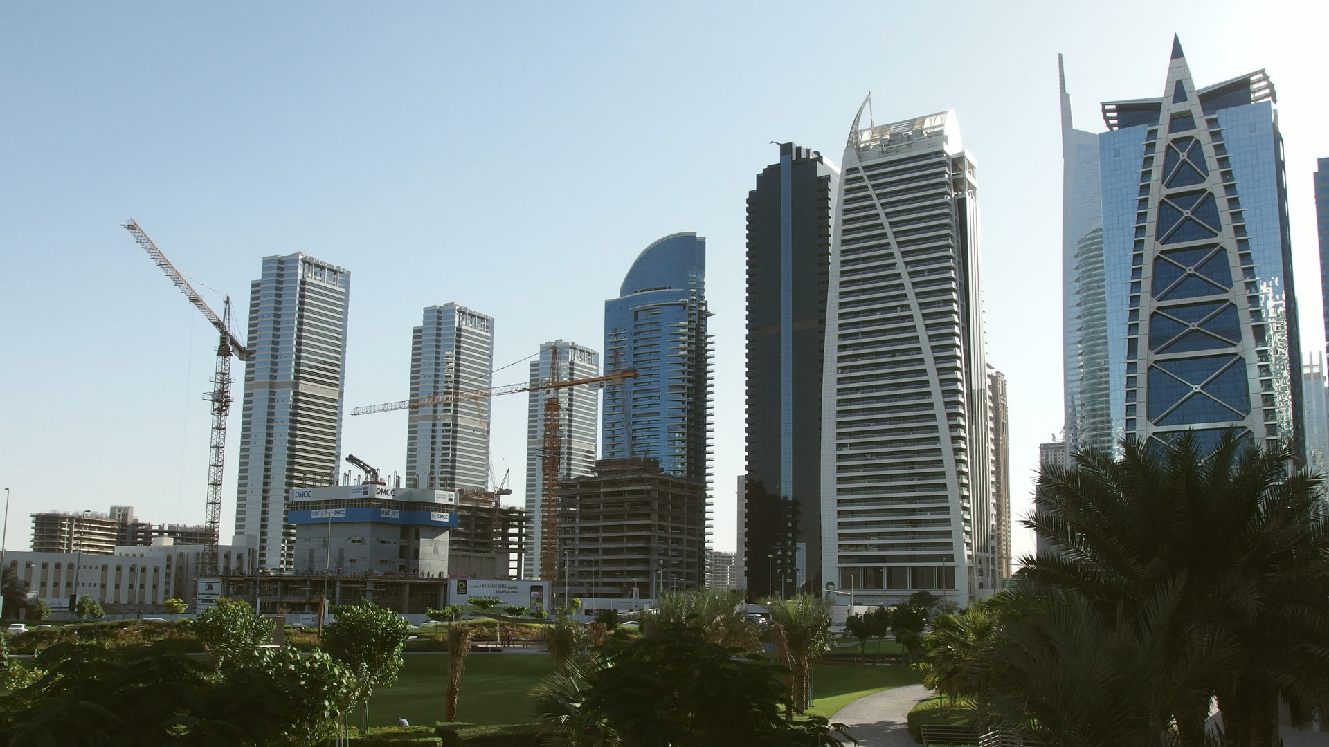 The towers of Jumeirah Lakes Towers in Dubai, seen across the park on a clear day