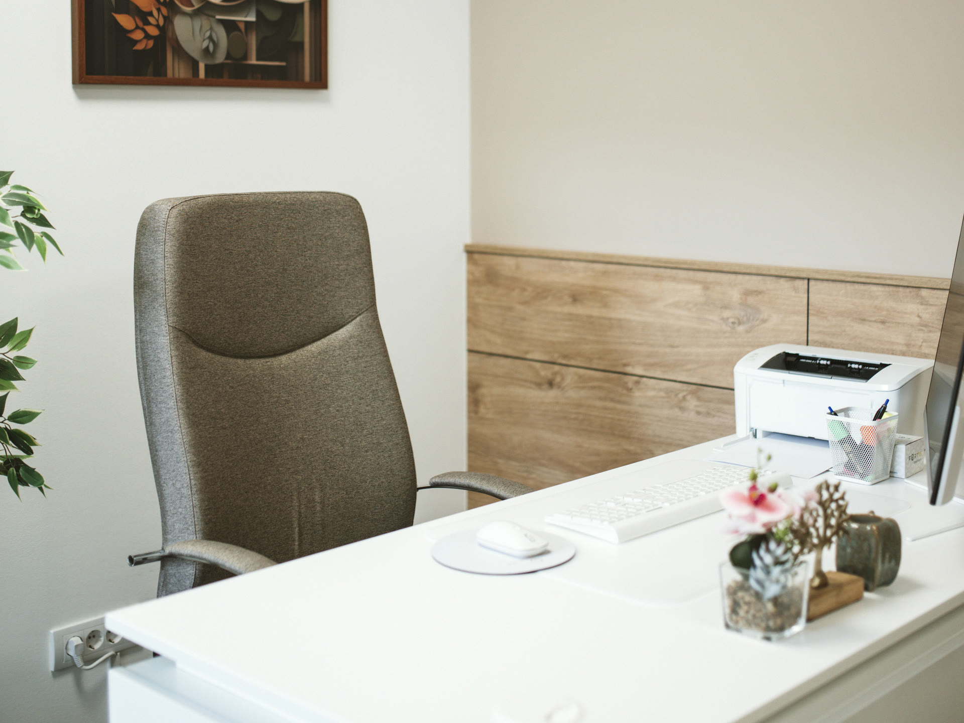 A small, tidy office: one desk, one chair, a printer and a picture on the wall